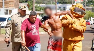 Morador (de camisa vermelha) e bombeiros tentam conter o suspeito (Foto: Henrique Kawaminami) - CREDITO: CAMPO GRANDE NEWS