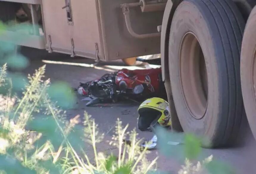 Motocicleta e capacete embaixo de carreta após acidente. (Foto: Paulo Francis) - CREDITO: CAMPO GRANDE NEWS