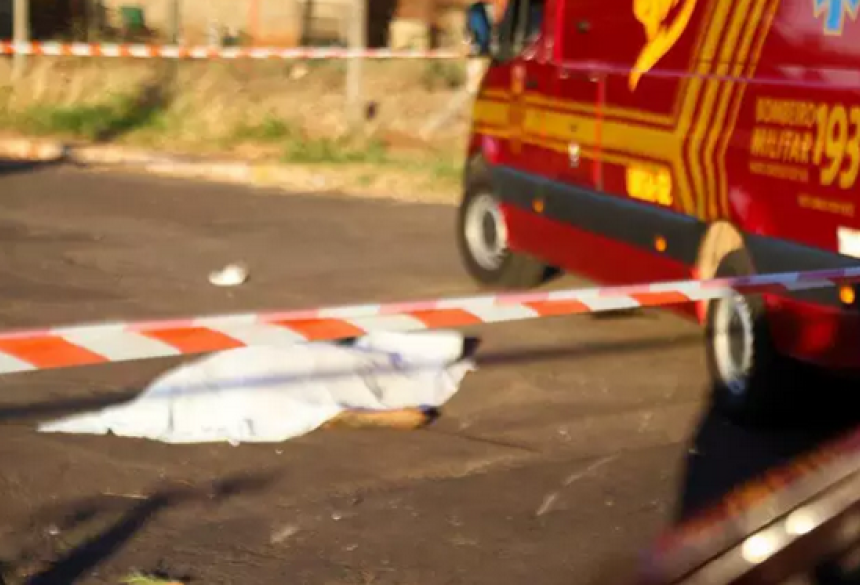 O corpo do rapaz está coberto por lençol branco no meio da Rua Jatobá