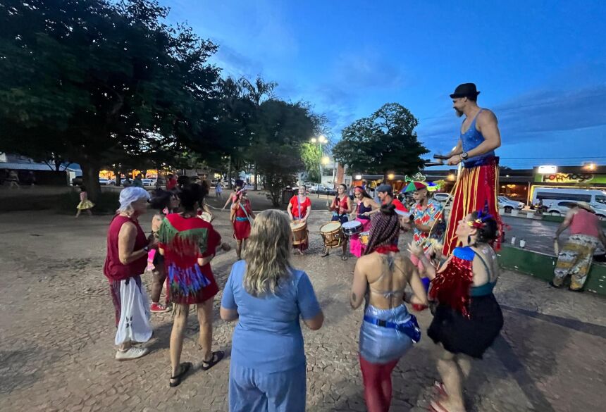 O cortejo contou com perna de pau circulando entre o público e tocando junto ao grupo, reforçando a inspiração circense