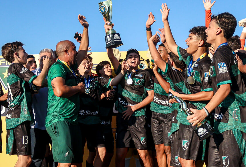 Jogadores do Pantanal levantam a taça de campeões estaduais Sub-15, a primeira comemoração do CD do Futebol (Foto: Rodrigo Moreira/@rmp.fotografia)