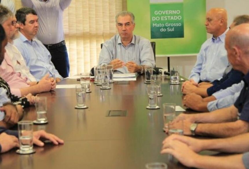 Governador Reinaldo Azambuja (centro) durante anúncio do 13° salário com a participação de secretários e representantes do setor comercial (Foto: Marina Pacheco)